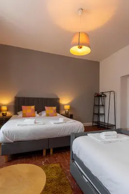 a bedroom with two beds and a lamp and a table at Abitarela - Maison d'Hôtes - B&B in Sigean