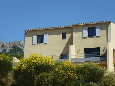 a house with a mountain in the background at LE COSY GITE in Duilhac