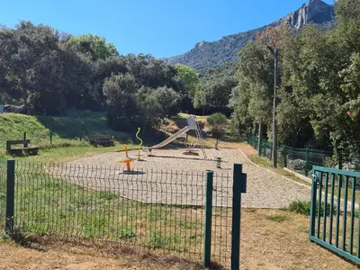 a playground behind a fence with at LE COSY GITE in Duilhac