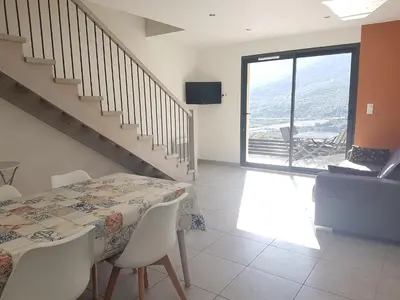 a dining room with a table and a staircase at LE COSY GITE in Duilhac