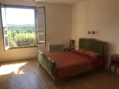 a bedroom with a bed and a large window at Librairie Abelard in Montolieu