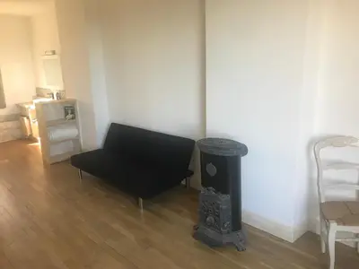 a living room with a black chair and a trash can at Librairie Abelard in Montolieu