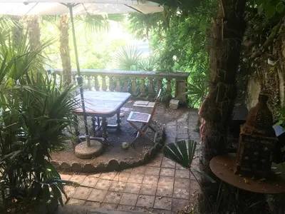 a patio with a table and an umbrella at Librairie Abelard in Montolieu