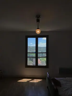 a bedroom with a window with a view at Librairie Abelard in Montolieu