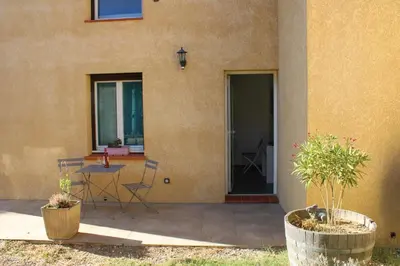 a patio with a table and chairs next to a building at Chambre d'hôte in Cucugnan