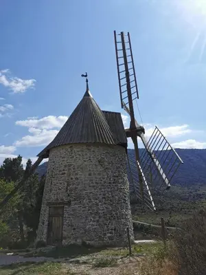 a windmill on a hill with the sun in the background at Chambre d'hôte in Cucugnan