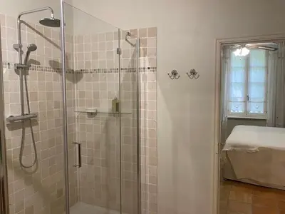 a bathroom with a shower with a glass door at Sainte-Hélène Chambres d'Hôtes & Appartement in Olonzac