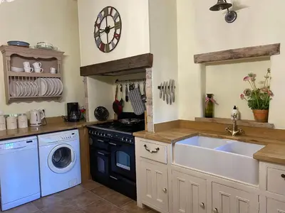 a kitchen with a sink and a washing machine at Sainte-Hélène Chambres d'Hôtes & Appartement in Olonzac