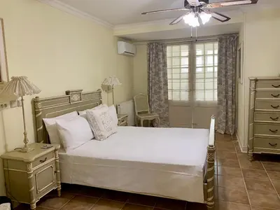 a bedroom with a white bed and a ceiling fan at Sainte-Hélène Chambres d'Hôtes & Appartement in Olonzac