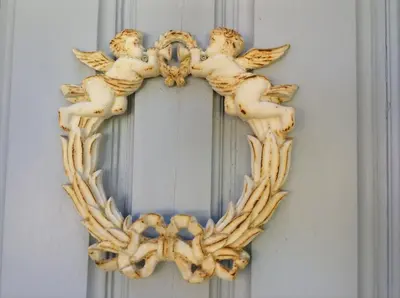 a wooden christmas wreath with cherubs on a wall at Aux Anges Gardiens in Carcassonne
