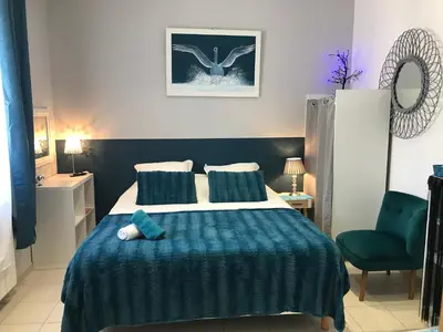a bedroom with a large bed with a blue blanket at La Turenne in Narbonne