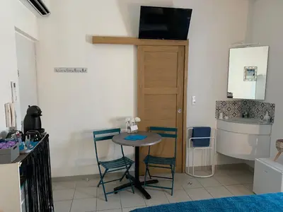 a kitchen with a table and two chairs and a sink at La Turenne in Narbonne