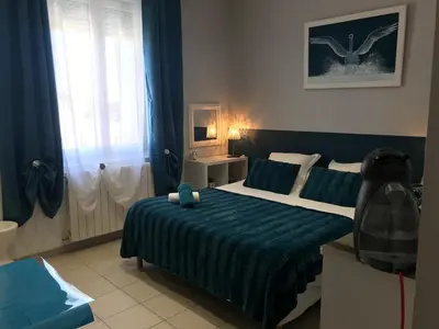 a bedroom with a large bed with a blue blanket at La Turenne in Narbonne
