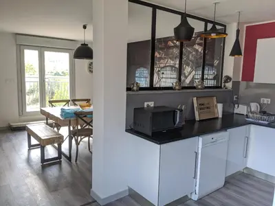 a kitchen with a counter with a microwave and a table at LA MAISON MIRAVA in La Caunette