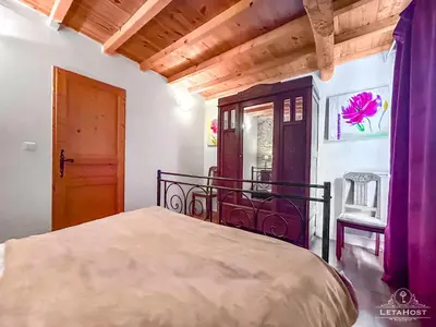 a bedroom with a bed and a door and a window at Charme rustique avec jardin privé 