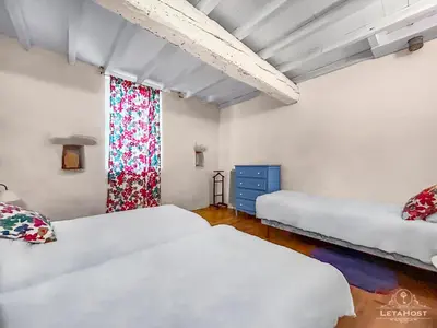 a bedroom with two beds and a window at Charme rustique avec jardin privé 
