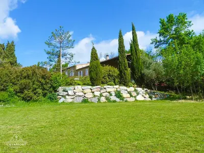 a stone wall in front of a house at Charme rustique avec jardin privé 