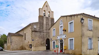 an old church with a tower on the side of it at Charme rustique avec jardin privé 