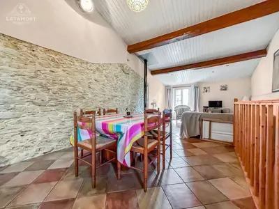 a dining room with a table and chairs at Charme rustique avec jardin privé 