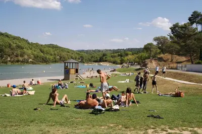 a group of people sitting on the grass at a beach at LE 31 in Carcassonne