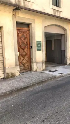 a building with a large wooden door on a street at Appartement spacieux à Carcassonne 48 m² avec parking in Carcassonne