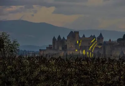 a group of buildings in a field with mountains in the background at Appartement spacieux à Carcassonne 48 m² avec parking in Carcassonne