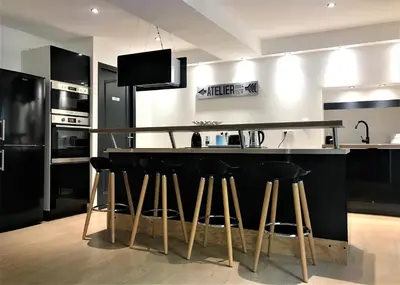 a kitchen with a counter with stools at a bar at La Maison Cachée in Carcassonne