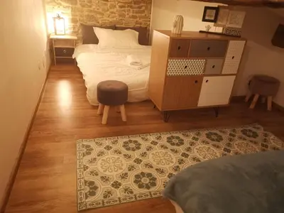 a bedroom with a bed and a cabinet and a rug at La Maison Cachée in Carcassonne