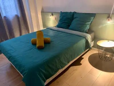 a bed with a teddy bear sitting on top of it at Spacieux Appartement Lumineux Cœur De Ville in Pamiers
