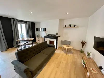 a living room with a couch and a table at Spacieux Appartement Lumineux Cœur De Ville in Pamiers