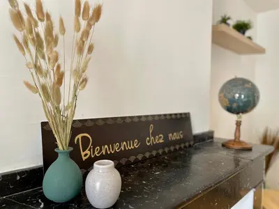 a table with two vases and a sign on it at Spacieux Appartement Lumineux Cœur De Ville in Pamiers