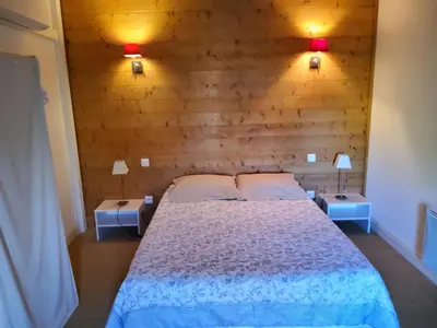 a bedroom with a bed with two tables and two lamps at Le Clos d'André in Castelnaudary
