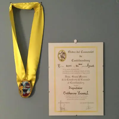 a gold medal next to a certificate on a wall at Le Clos d'André in Castelnaudary