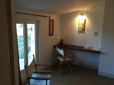 a room with a desk and two chairs and a window at Le Clos d'André in Castelnaudary