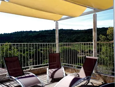 two chairs and an umbrella on a deck with a view at Chambre La Caunette in La Caunette
