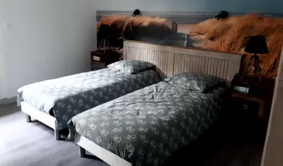a bedroom with two beds and a painting on the wall at Chambre La Caunette in La Caunette