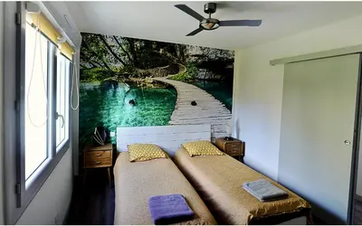 a bedroom with a painting on the wall at Chambre La Caunette in La Caunette