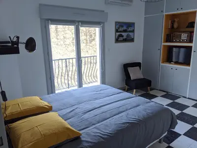 a bedroom with a bed and a chair and a window at Chambre La Caunette in La Caunette