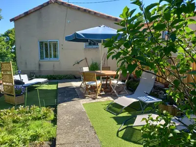a patio with a table and chairs and an umbrella at Vue sur L'Ourtizet in Rodome