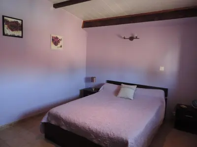a bedroom with a bed in a room with purple walls at Gîtes Le 
