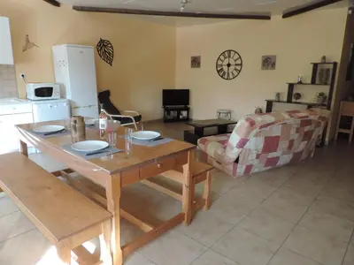 a kitchen and living room with a table and a couch at Gîtes Le 