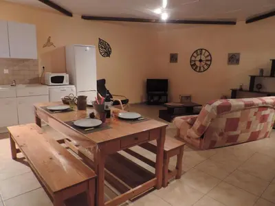 a kitchen and living room with a wooden table at Gîtes Le 