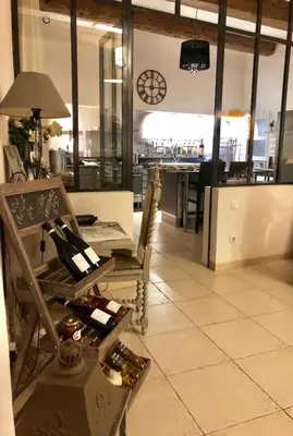 a room with a table and chairs and a kitchen at Au Paradis Cathare in Fraissé-des-Corbières