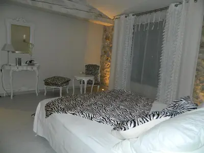 a bedroom with a bed and a table and a window at Au Paradis Cathare in Fraissé-des-Corbières