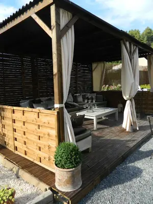 a wooden deck with a gazebo with a table at Au Paradis Cathare in Fraissé-des-Corbières