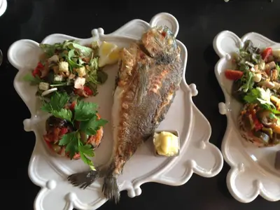 a plate of food with a fish and a salad at Au Paradis Cathare in Fraissé-des-Corbières