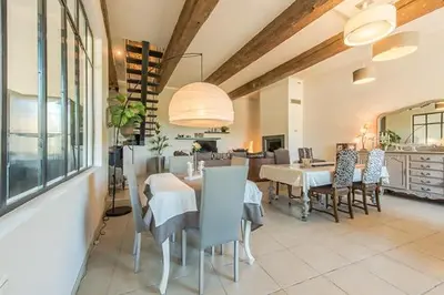 a dining room with a table and chairs and a kitchen at Au Paradis Cathare in Fraissé-des-Corbières