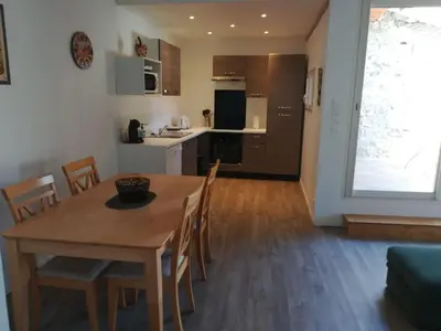 a kitchen and dining room with a wooden table and chairs at La Limonadière in Port-la-Nouvelle