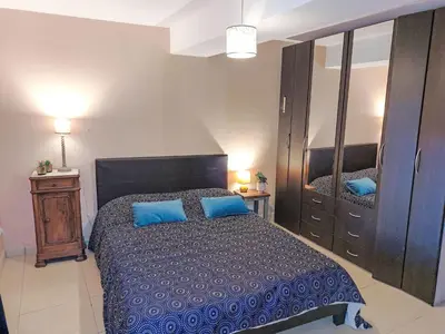 a bedroom with a large bed with blue pillows at Holiday Home La Maison de l'Etang by Interhome in Gruissan