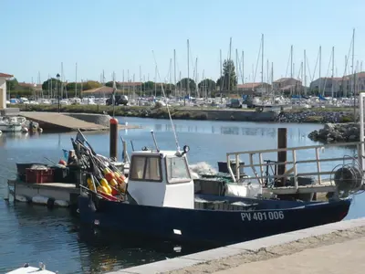 a small boat docked at a dock in the water at Holiday Home La Maison de l'Etang by Interhome in Gruissan